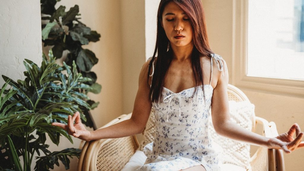 a woman sitting in a chair with her hands in the air